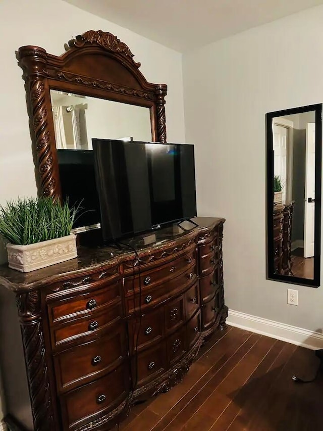 bedroom with dark hardwood / wood-style flooring