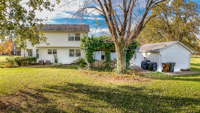 rear view of property with a lawn and central air condition unit