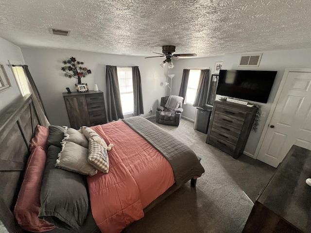 bedroom with carpet flooring, ceiling fan, and a textured ceiling