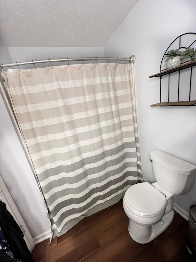 bathroom featuring hardwood / wood-style floors, toilet, and a textured ceiling