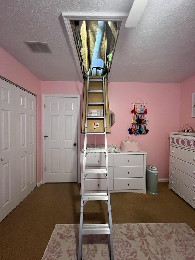 carpeted bedroom featuring a textured ceiling and a closet