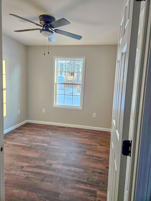 spare room featuring ceiling fan and dark hardwood / wood-style floors