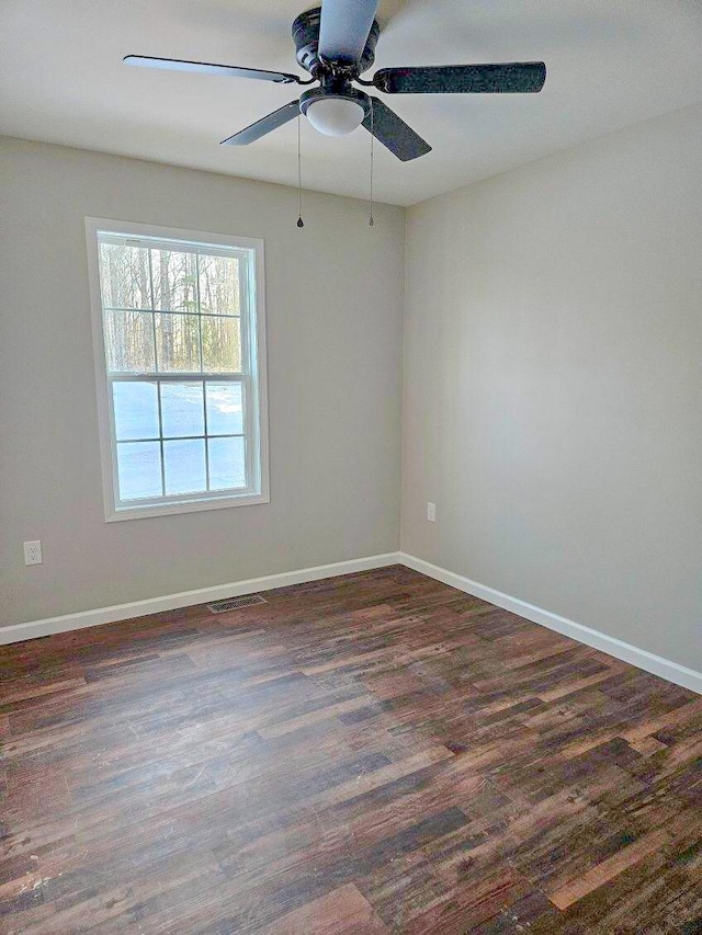 empty room with dark hardwood / wood-style flooring and ceiling fan