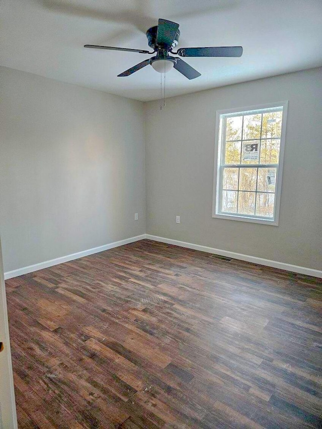 spare room with ceiling fan and dark wood-type flooring