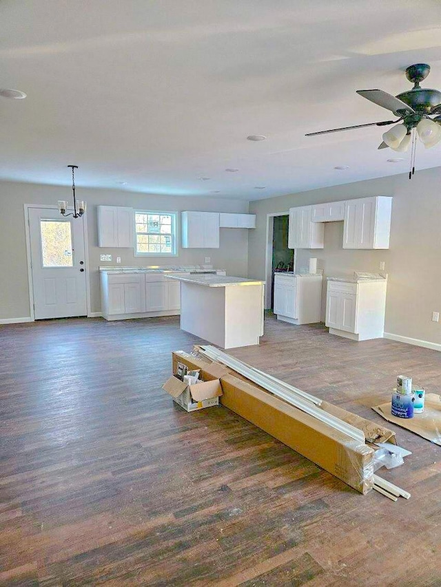 interior space with ceiling fan with notable chandelier and dark hardwood / wood-style flooring