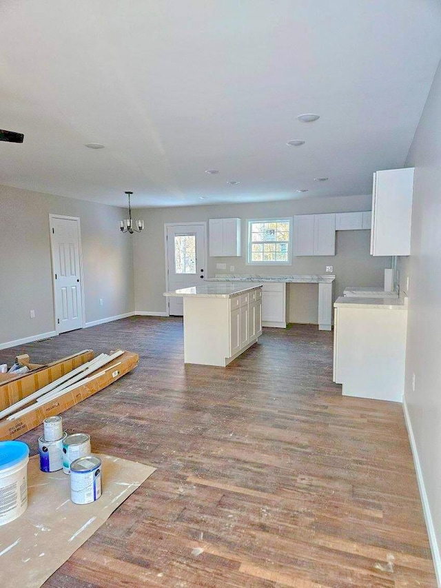 kitchen featuring hanging light fixtures, a center island, white cabinets, light hardwood / wood-style flooring, and an inviting chandelier