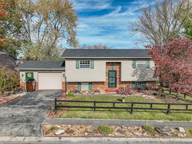 raised ranch with a front lawn and a garage