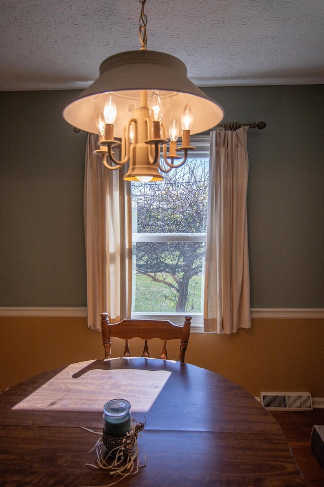 dining room featuring a textured ceiling and a notable chandelier