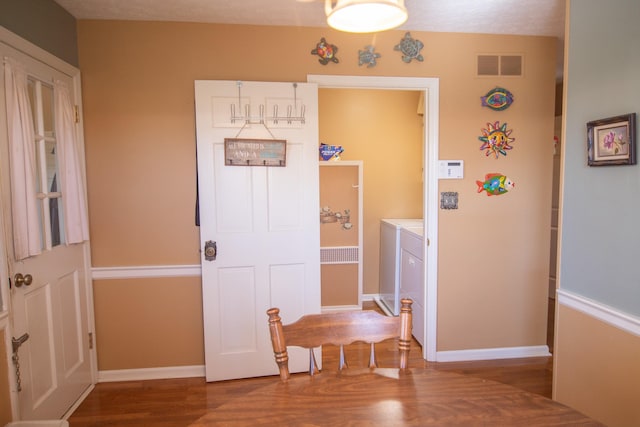 hallway featuring a textured ceiling, hardwood / wood-style flooring, and washer and dryer