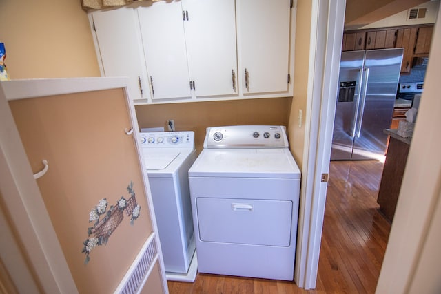 washroom featuring light hardwood / wood-style flooring, cabinets, and washing machine and clothes dryer