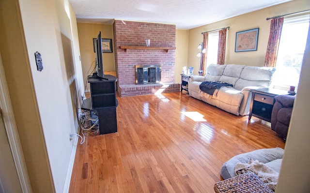 living room featuring a textured ceiling, hardwood / wood-style flooring, and a fireplace