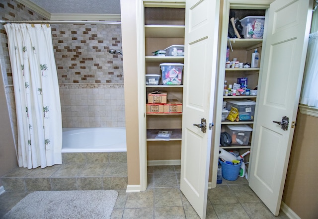 bathroom with shower / tub combo with curtain, a textured ceiling, tile patterned floors, and ornamental molding