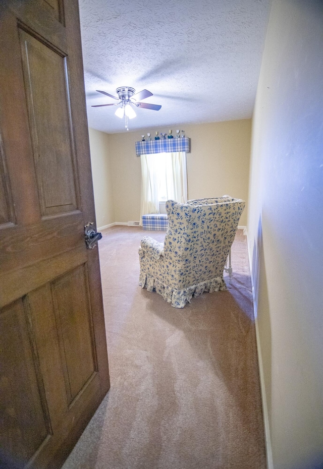 carpeted bedroom featuring ceiling fan and a textured ceiling