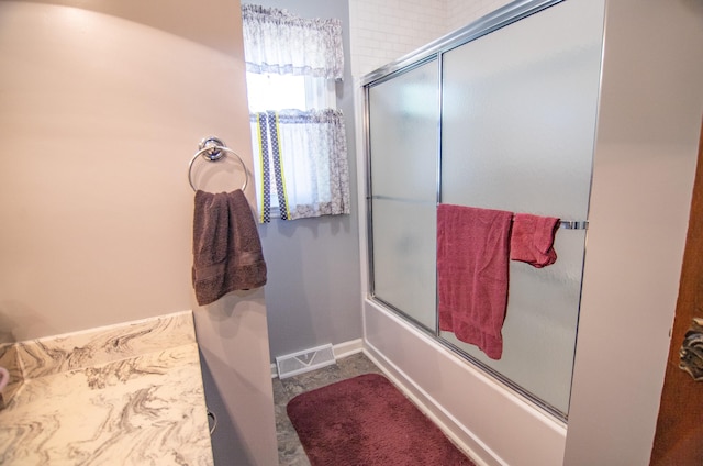 bathroom featuring bath / shower combo with glass door