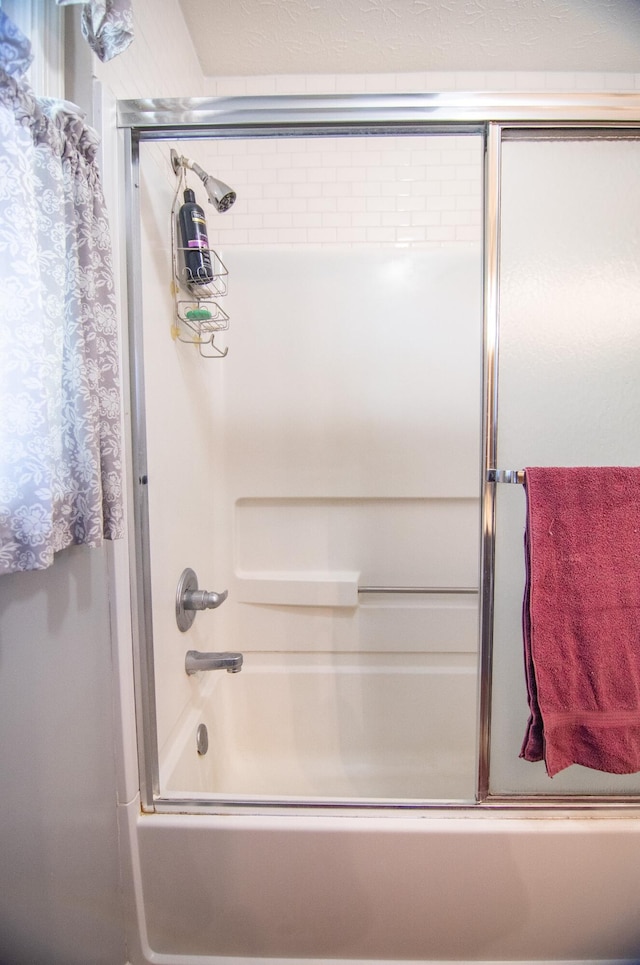 bathroom with combined bath / shower with glass door