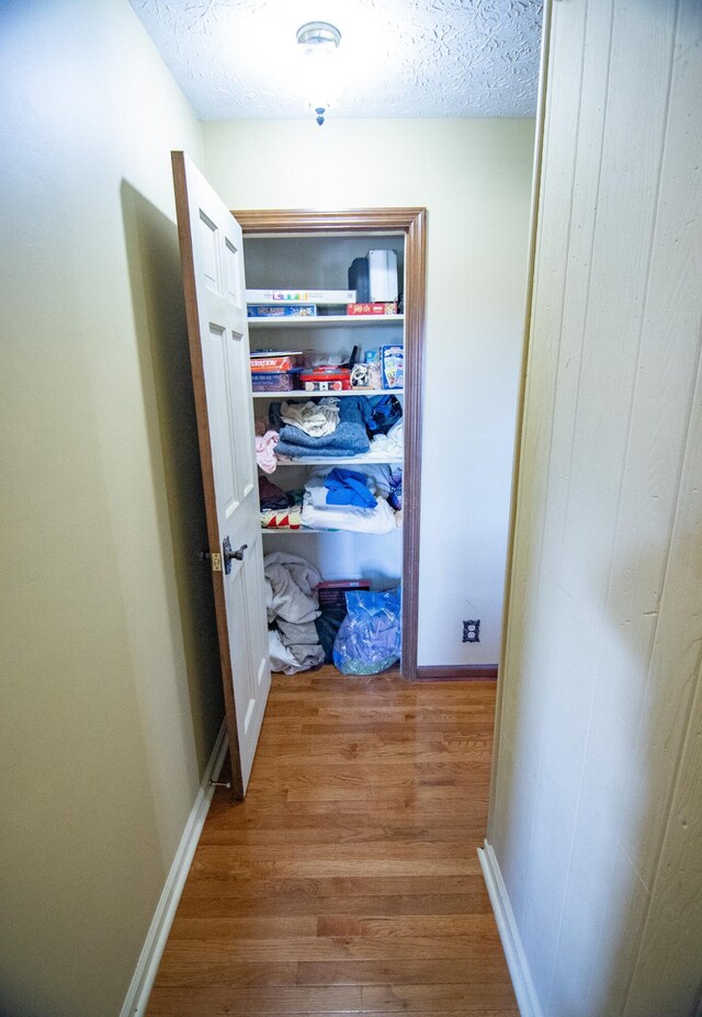 hallway featuring hardwood / wood-style floors and a textured ceiling