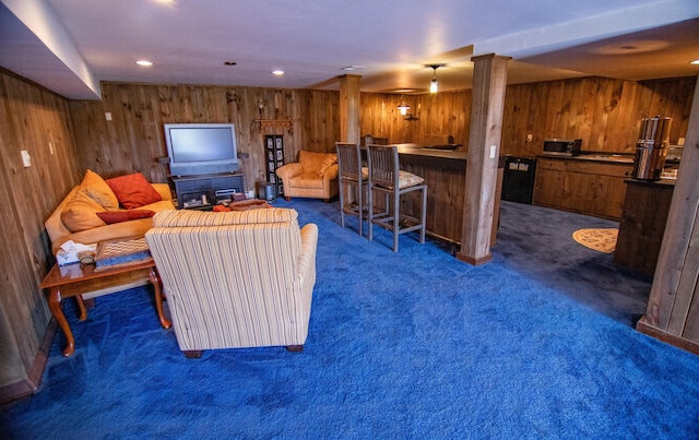 living room featuring dark colored carpet, bar, and wood walls