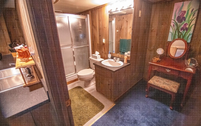 bathroom featuring vanity, wood walls, an enclosed shower, and toilet