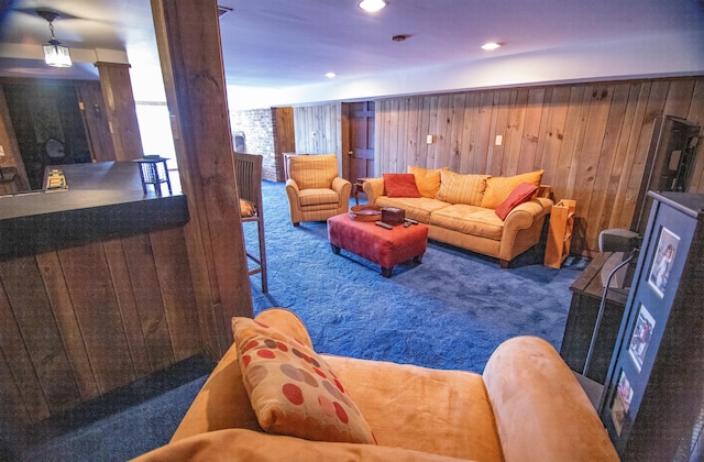 carpeted living room with wooden walls