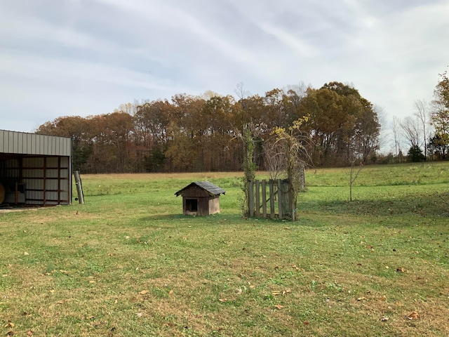 view of yard with a rural view and an outbuilding