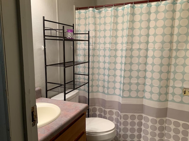 bathroom with toilet, vanity, and curtained shower