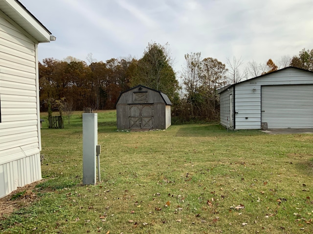 view of yard with a garage and an outbuilding