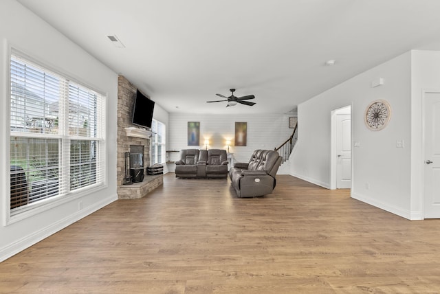 living room with a fireplace, light hardwood / wood-style floors, and ceiling fan