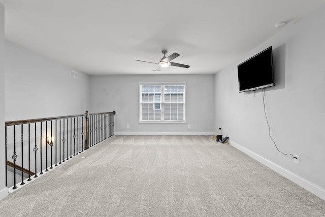 empty room featuring light colored carpet and ceiling fan