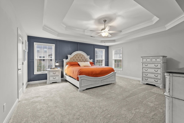 bedroom with multiple windows, carpet floors, ceiling fan, and a raised ceiling