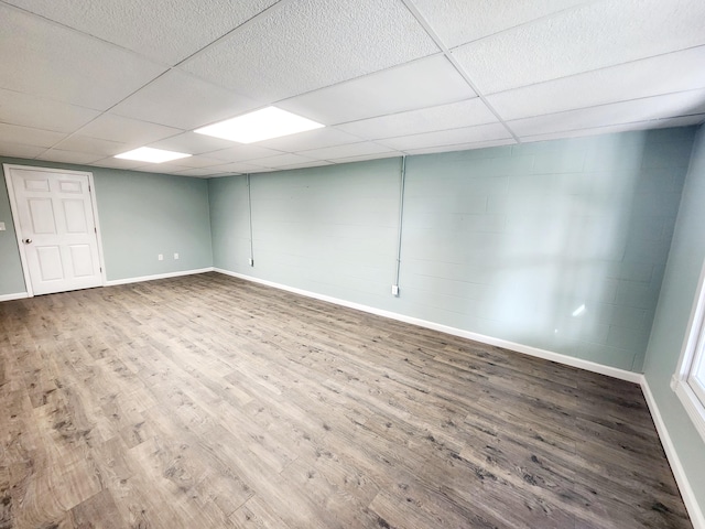 basement with a paneled ceiling and hardwood / wood-style floors