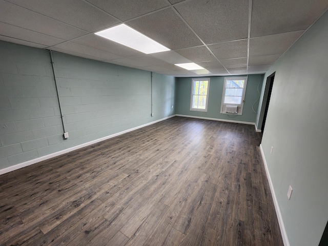 empty room with dark hardwood / wood-style floors, a paneled ceiling, and cooling unit