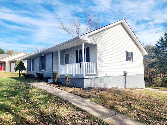 view of side of home featuring a porch and a yard