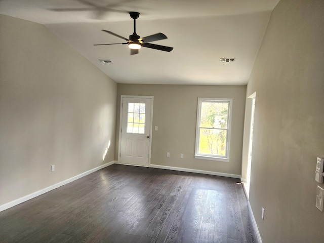 unfurnished room featuring a wealth of natural light, ceiling fan, vaulted ceiling, and dark hardwood / wood-style flooring