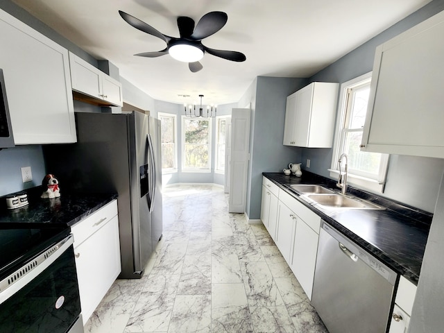 kitchen featuring ceiling fan with notable chandelier, hanging light fixtures, sink, white cabinetry, and appliances with stainless steel finishes