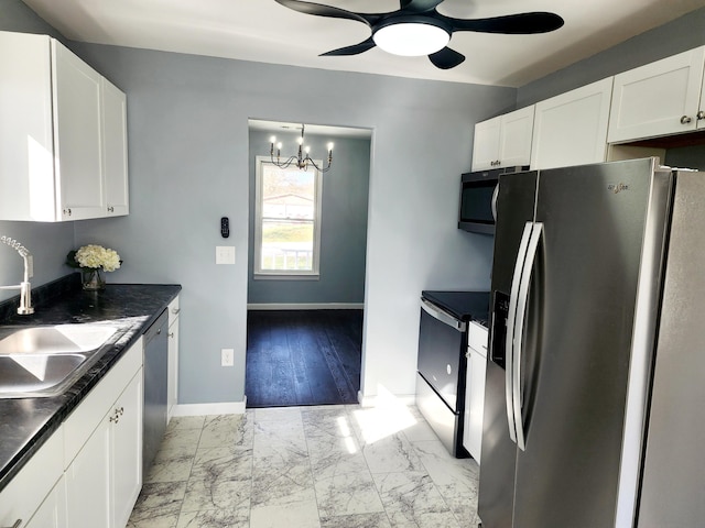 kitchen featuring ceiling fan with notable chandelier, stainless steel appliances, light hardwood / wood-style floors, white cabinets, and sink