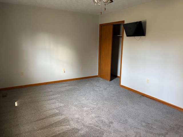 empty room with carpet flooring and a textured ceiling