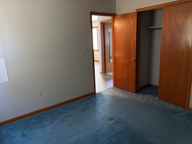 unfurnished bedroom with a closet and dark colored carpet