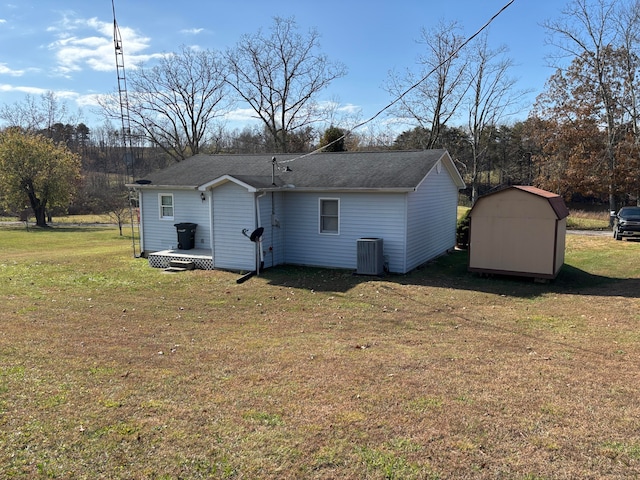 rear view of house featuring a yard and a shed