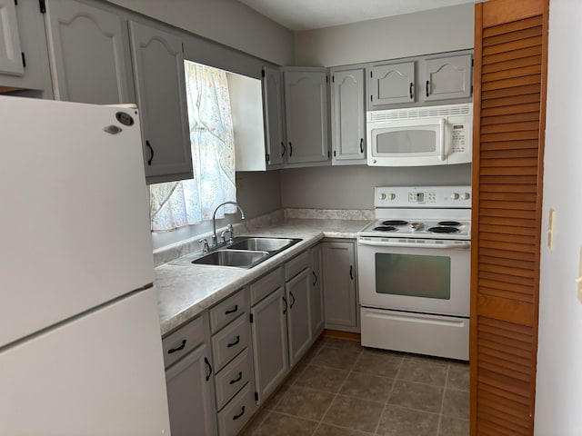 kitchen with gray cabinets, sink, and white appliances