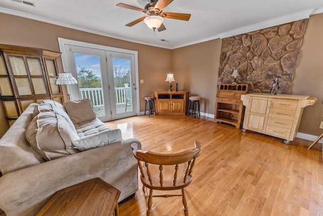 living room with ceiling fan, ornamental molding, and light hardwood / wood-style flooring