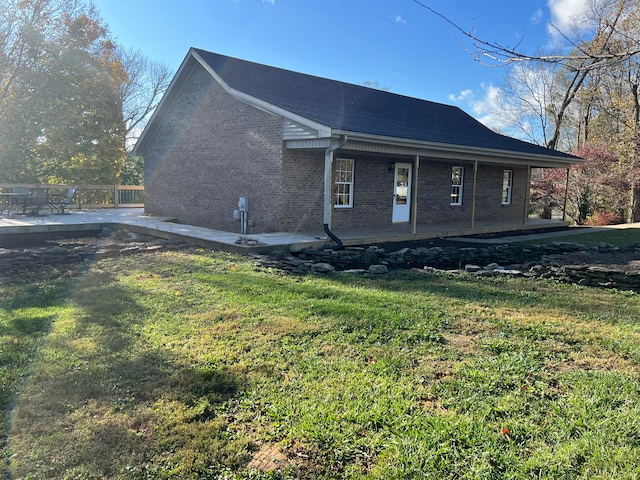 view of side of property with a lawn and a patio