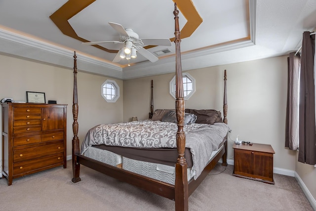 bedroom featuring a raised ceiling, ceiling fan, light carpet, and multiple windows