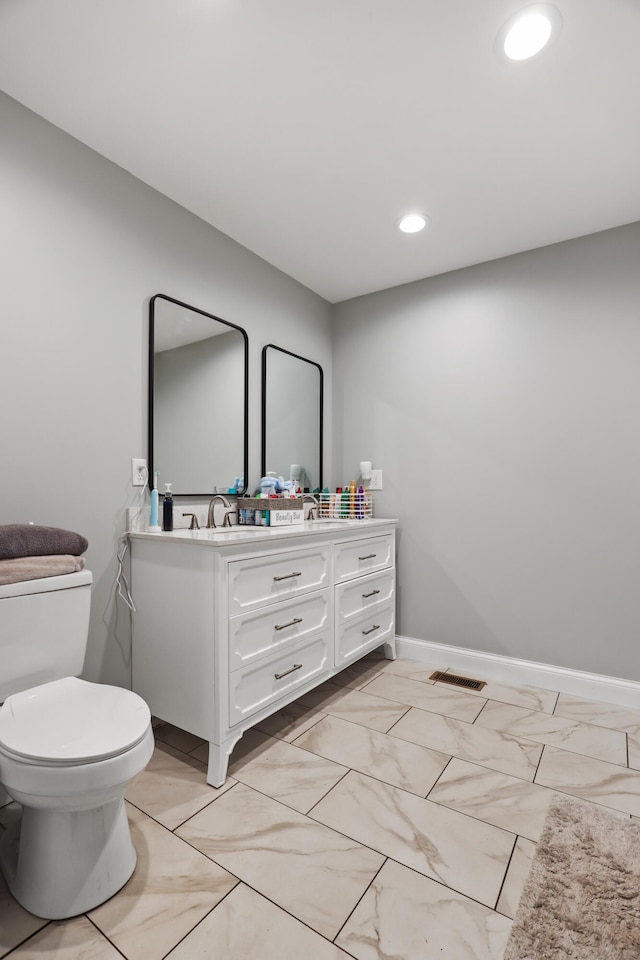 bathroom featuring toilet and vanity