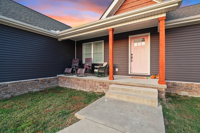 exterior entry at dusk with a lawn and a porch