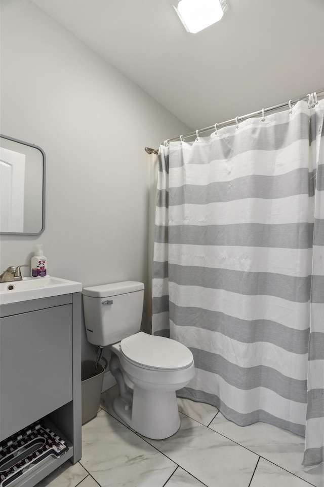 bathroom featuring toilet, vanity, and walk in shower