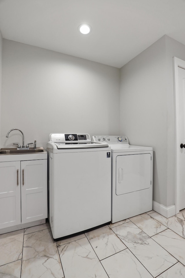 laundry area with cabinets, washer and dryer, and sink