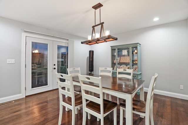 dining space featuring french doors, an inviting chandelier, and dark hardwood / wood-style flooring