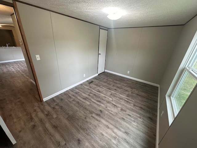 interior space with a textured ceiling and dark hardwood / wood-style flooring