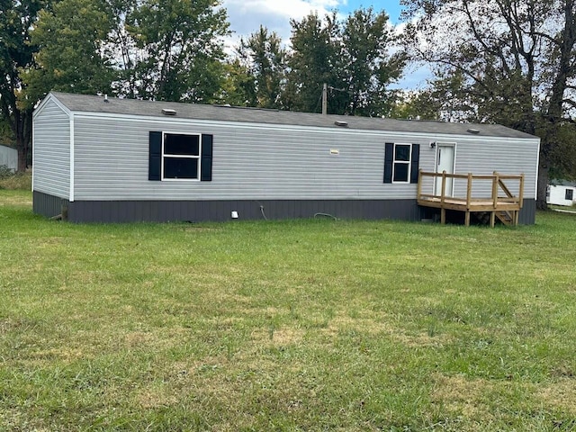 back of property featuring a wooden deck and a lawn