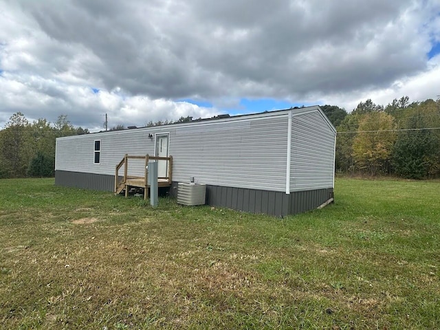 exterior space featuring central air condition unit and a yard